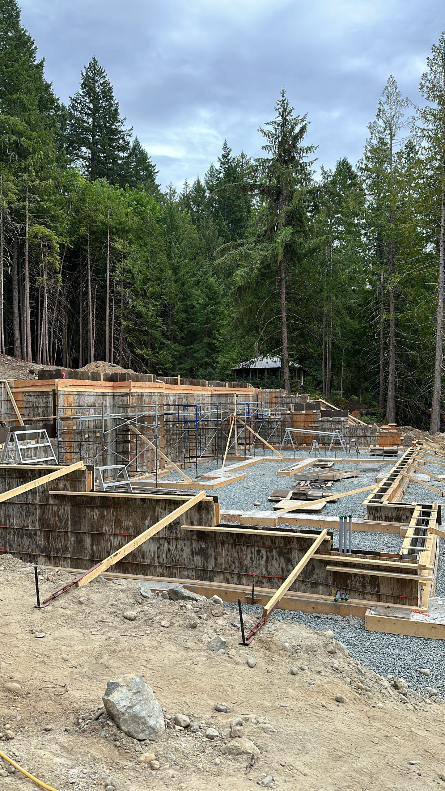 Foundation stage of a custom home build in the Cowichan Valley, surrounded by dense West Coast forest—highlighting early-phase craftsmanship by local luxury home builders on Vancouver Island